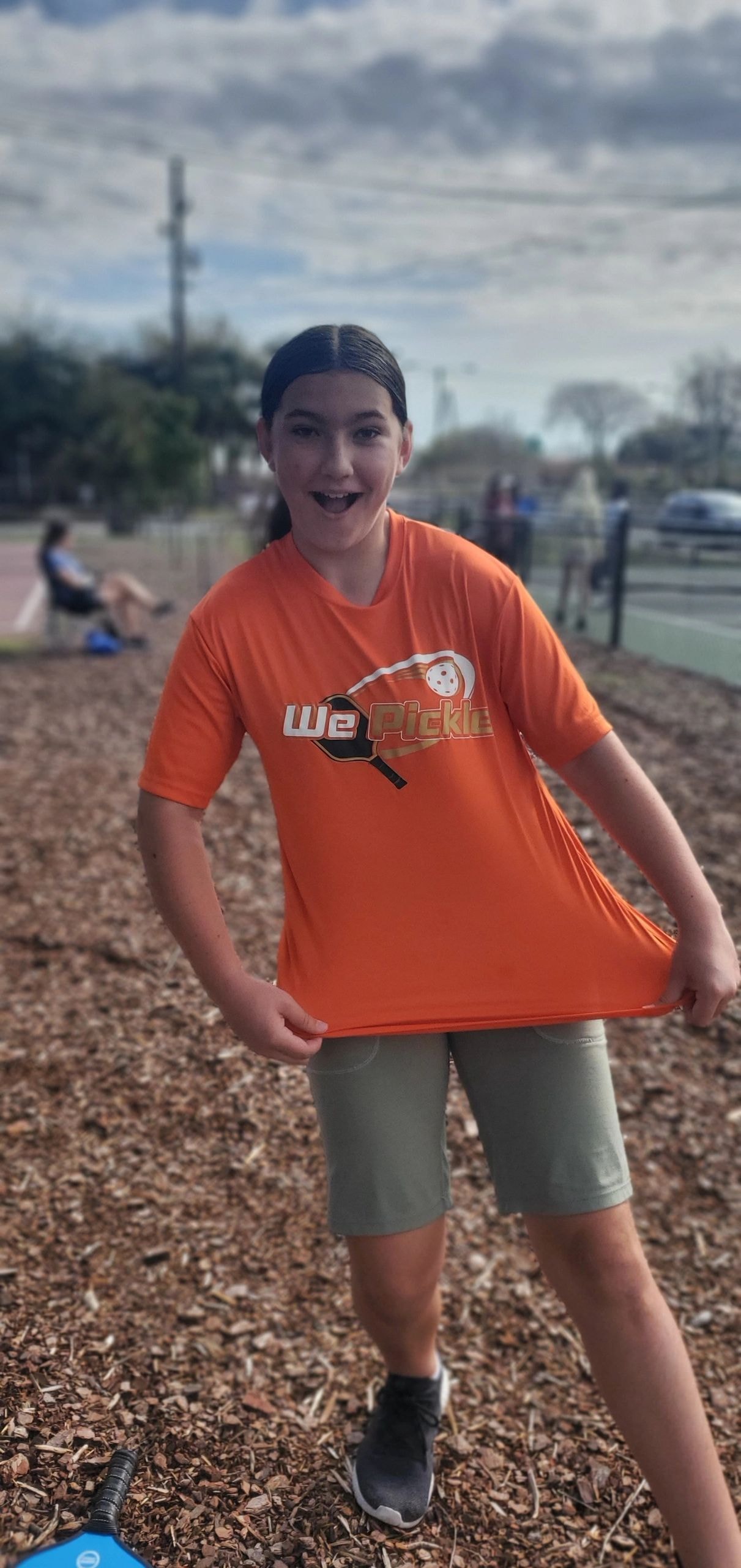 Player smiling at pickleball court outdoors